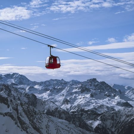 A vertical shot of a cabin of the ropeway over the mountains